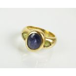 A three stone tanzanite and peridot dress ring,