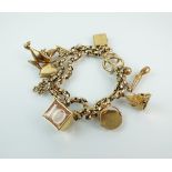 A yellow metal double link bracelet with attached 9ct gold and yellow metal charms,