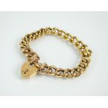 A yellow metal hollow curb link bracelet, the heart shaped padlock clasp stamped '9ct',