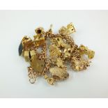 A 9ct gold double link charm bracelet, with attached 9ct gold and yellow metal charms,