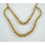 A yellow metal graduated bead necklace,