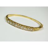 An 18ct gold diamond set hinged bangle,