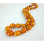 A graduated amber bead necklace, comprising forty-nine oval beads, with screw fastening, 81cm long,