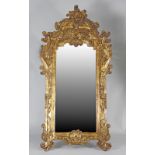 A modern Rococo style pier mirror, the giltwood framed heavily carved with scrolling leaves,