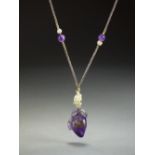 A Chinese amethyst pendant, Qing Dynasty, carved as a peach supported by a knotty branch,