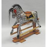 A dappled grey rocking horse, on a pine swing action rocking base,