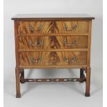 A 20th century mahogany veneered Chippendale style chest of three long graduated cockbeaded drawers