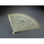 A Chinese ivory brise fan, 19th Century, the guards carved with meandering flowers and foliage,