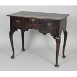 A mid 18th century oak lowboy the rectangular plank top over an arrangement of three short drawers