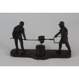 A German mid brown patinated bronze cased, cast metal sculpture, of two foundry workers,