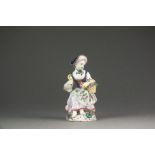 A Bow porcelain figure of Columbine seated holding a basket of fruit, circa 1755,