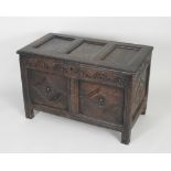 A late 17th century joined oak coffer the hinged three panel lid over a lunette carved frieze and