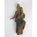 A polychrome decorated carved wood figure of the Virgin Mary holding the Christ child,