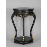 A modern ebonised chinoiserie style urn stand on four well shaped supports and shelf base stretcher,