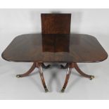 A Regency style mahogany twin pillar dining table with one additional leaf on short columns,