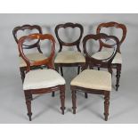 A matched set of ten Victorian mahogany dining chairs each with a shaped top rail above an