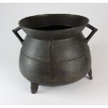 A 17th century dark brown patinated bronze two handled cauldron on three splay legs,