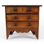 A 19th century mahogany table top miniature chest of three long drawers,