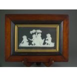 A framed rectangular Wedgwood black jasperware plaque decorated with four putto seated beside a