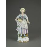 A Sitzendorf porcelain figure of a female flower seller, underglaze blue factory mark, 19th century,