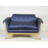 A pair of giltwood Empire style sofas each covered in a deep blue Damask style fabric on channel