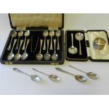 A cased pair of silver spoons together with a cased set of twelve silver teaspoons and a pair of