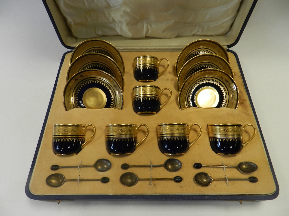 A boxed set of Limoges porcelain coffee cups and saucers with acid gilt decoration on a dark blue