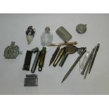 Two brass policeman's whistle, a silver retractable pencil,