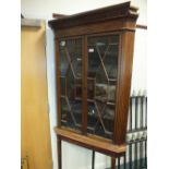 A 19th century mahogany boxwood line strung corner display cabinet on stand