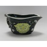 A Chinese famille noire style sauce boat, decorated with taotie masks,