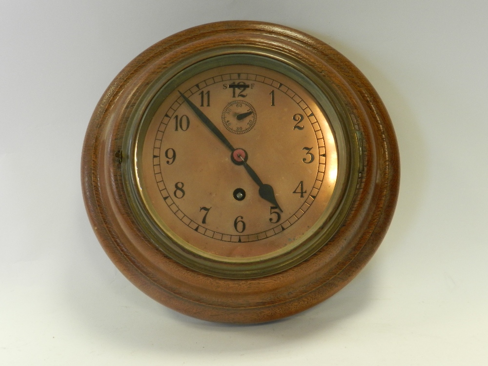 A circular oak cased wall time piece with Arabic numerals,