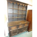 A 20th century dark stained oak high dresser with boarded delft rack