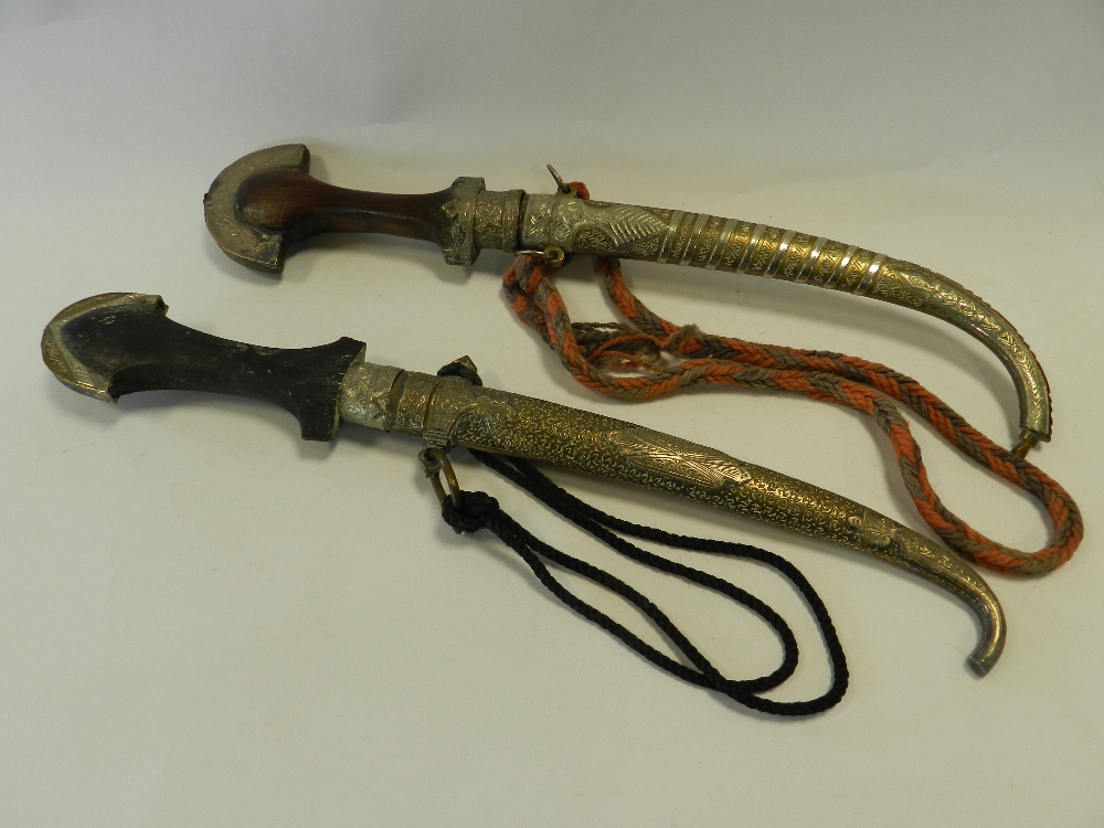 Two Middle Eastern jambiya style daggers in metal scabbards