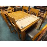 An oak extending dining table along with a set of four bar back dining chairs and two further