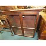 A dark stained oak glazed bookcase (lacking base)