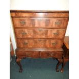 A George III style quarter veneered mahogany chest on stand with three long drawers above two apron