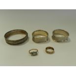 Two silver napkin rings together with a silver bangle,