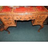 A walnut veneered 18th century style desk with serpentine front,