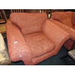 A modern salmon covered two seater settee and enclosed armchair en suite