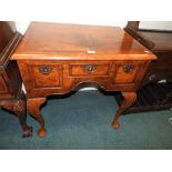 A George I style quarter veneered crossbanded walnut lowboy with three drawers on shell headed