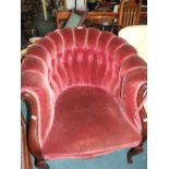 A Victorian button back tub chair finished in a claret plush