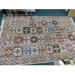 A Moroccan cream ground rug with multi coloured fields with rectangular and geometric medallions