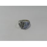 A 9ct white gold tanzanite set dress ring formed as a stylised ribbon