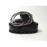 A Post and Co. black leather belt with silver ornate oval buckle studding and leather detailing to