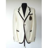 A Gucci jacket, cream with black edging detail, black and gold Gucci crest embroidered badge to