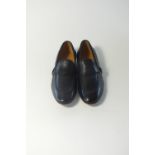 A pair of Gucci slip-on shoes, black, leather, detailing to mimic tack, Gucci stamp to heel, brass