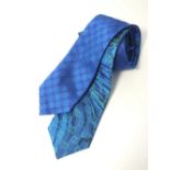 Two Gucci ties, one blue with dark blue Gucci logo pattern, one blue with Gucci green logo pattern