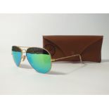 A pair of Ray Ban Aviators, gold frame with green mirrored lenses