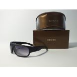 A pair of cased black Gucci sunglasses in case