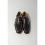 A pair of Gucci slip-on loafers, dark brown leather, with cream piping detail and Gucci silver